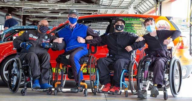 4- disabled vets in-wheelchairs near race car