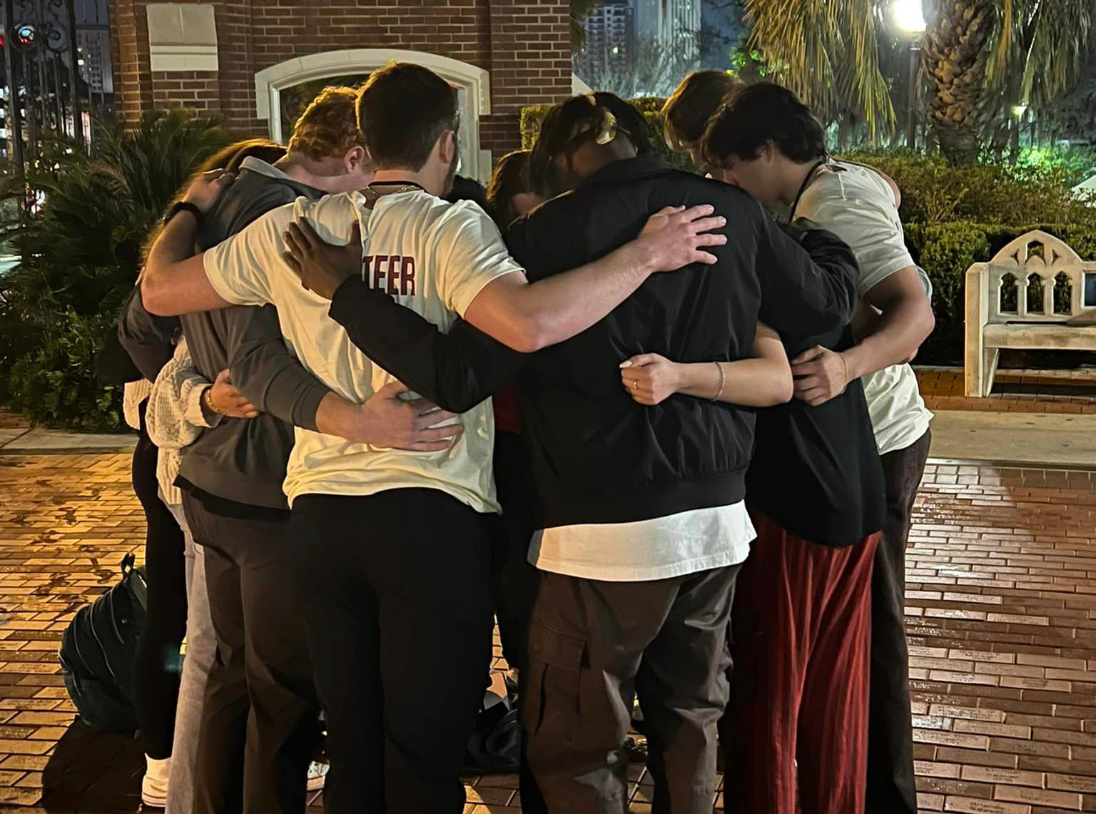 College-aged men do a group hugs at UniteUs event