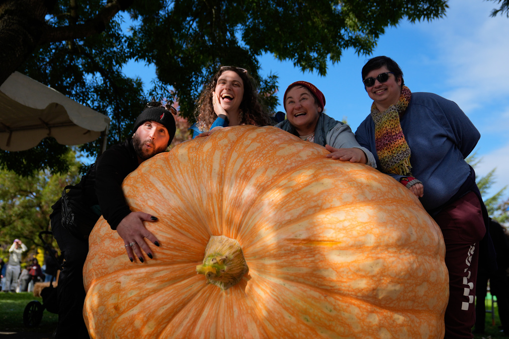 From left, Brod Salo, Julia, Rae Nathanson and Ellis Lorant pose with a giant pumpkin during the West Coast Giant Pumpkin Regatta