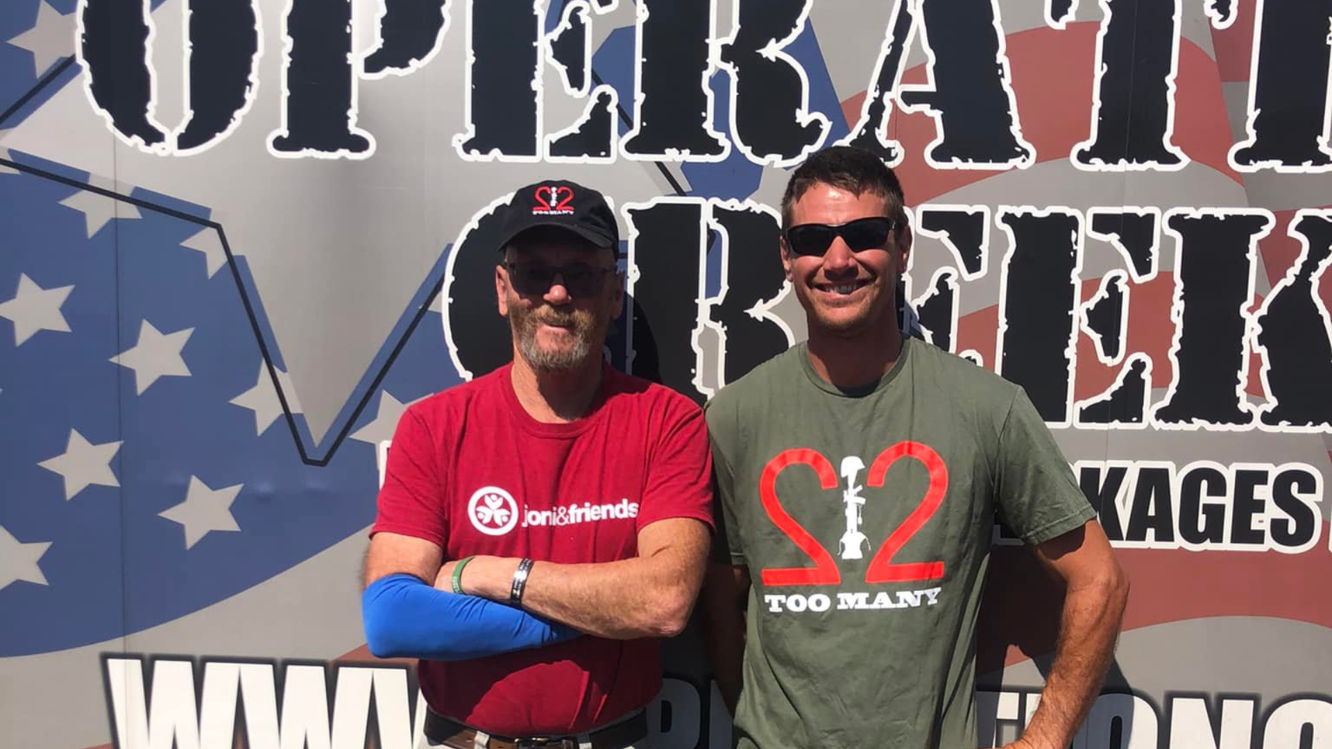 McClelland and a 22 Too Many team member in front of the Operation Creekside trailer.