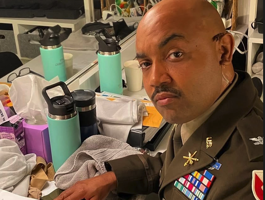 Man in uniform in dressing room, studying acting lines