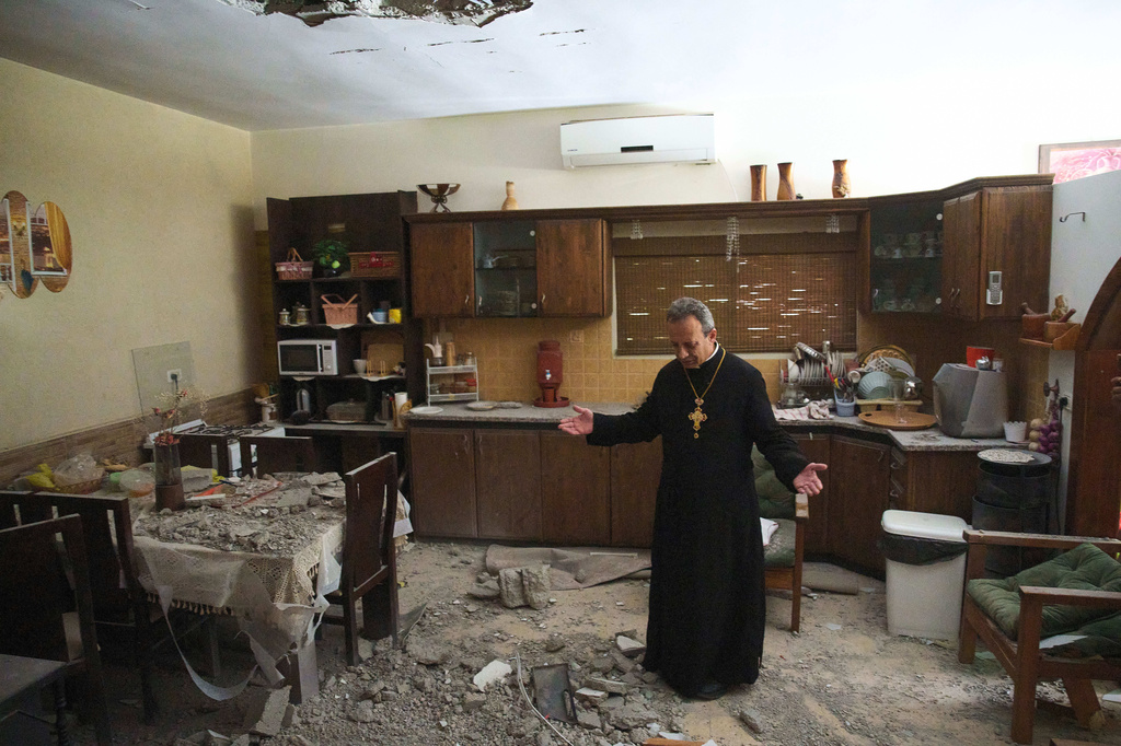 Monsignor Simon Khoury inspects a damaged house following an Iranian missile strike in Shefaram, Israel