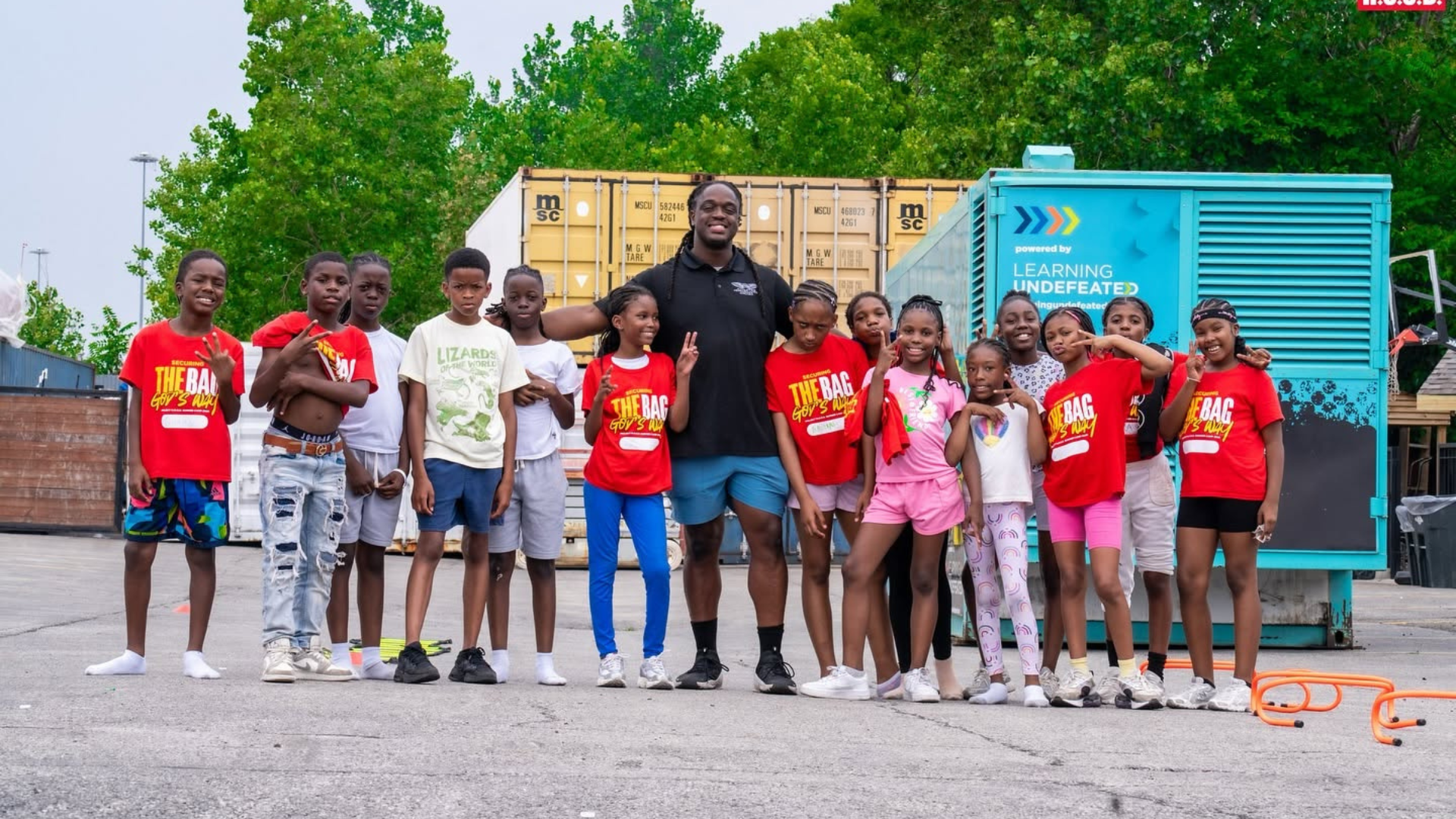 A Project H.O.O.D. leader surrounded by summer camp attendees.