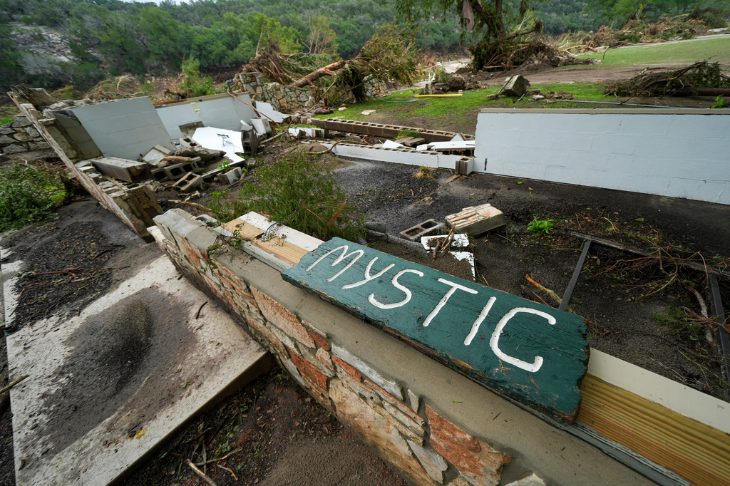 Damaged Camp Mystic sign along the banks of the Guadalupe River in Hunt, Texas