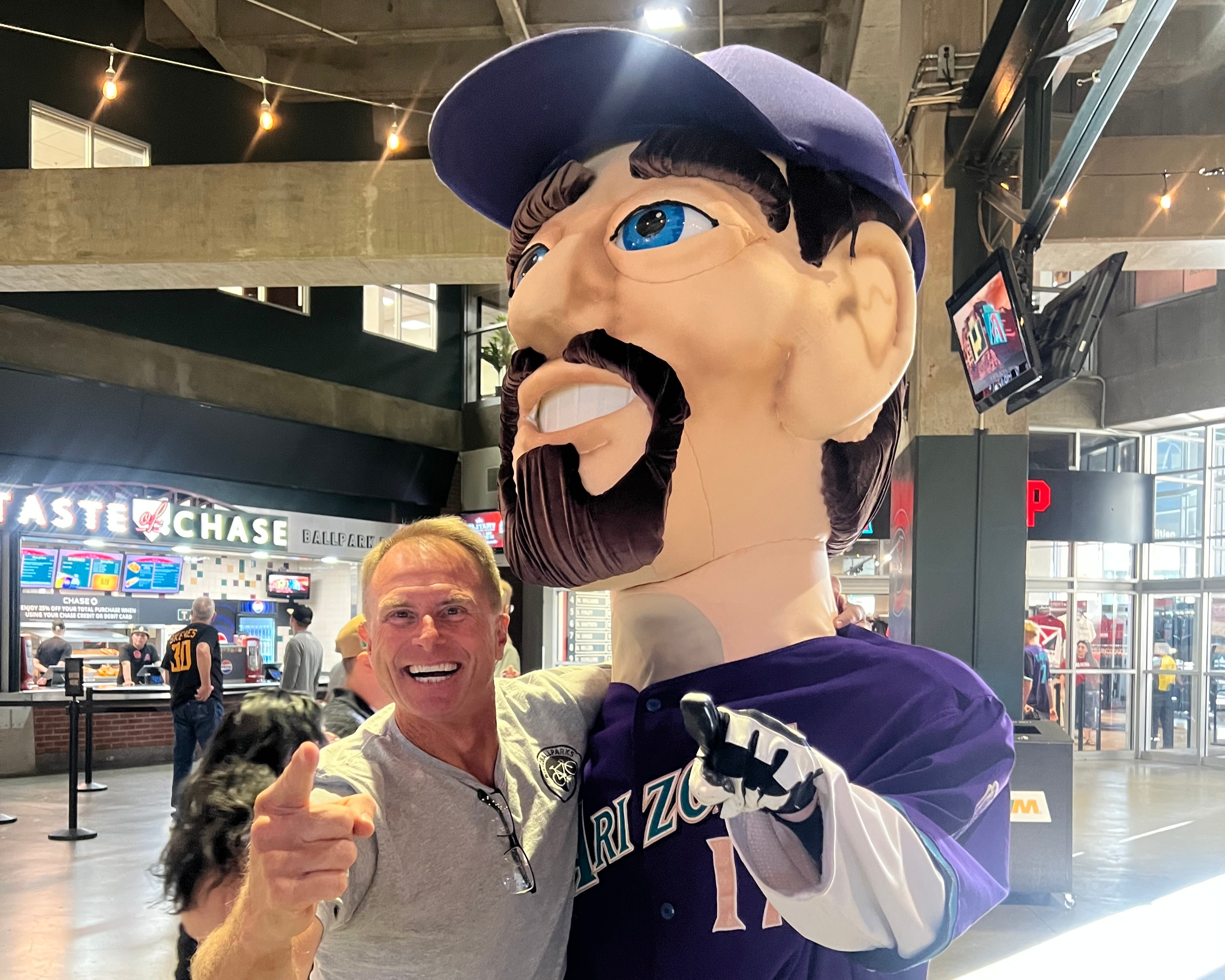 Scott Pesch taking a photograph with a mascot.