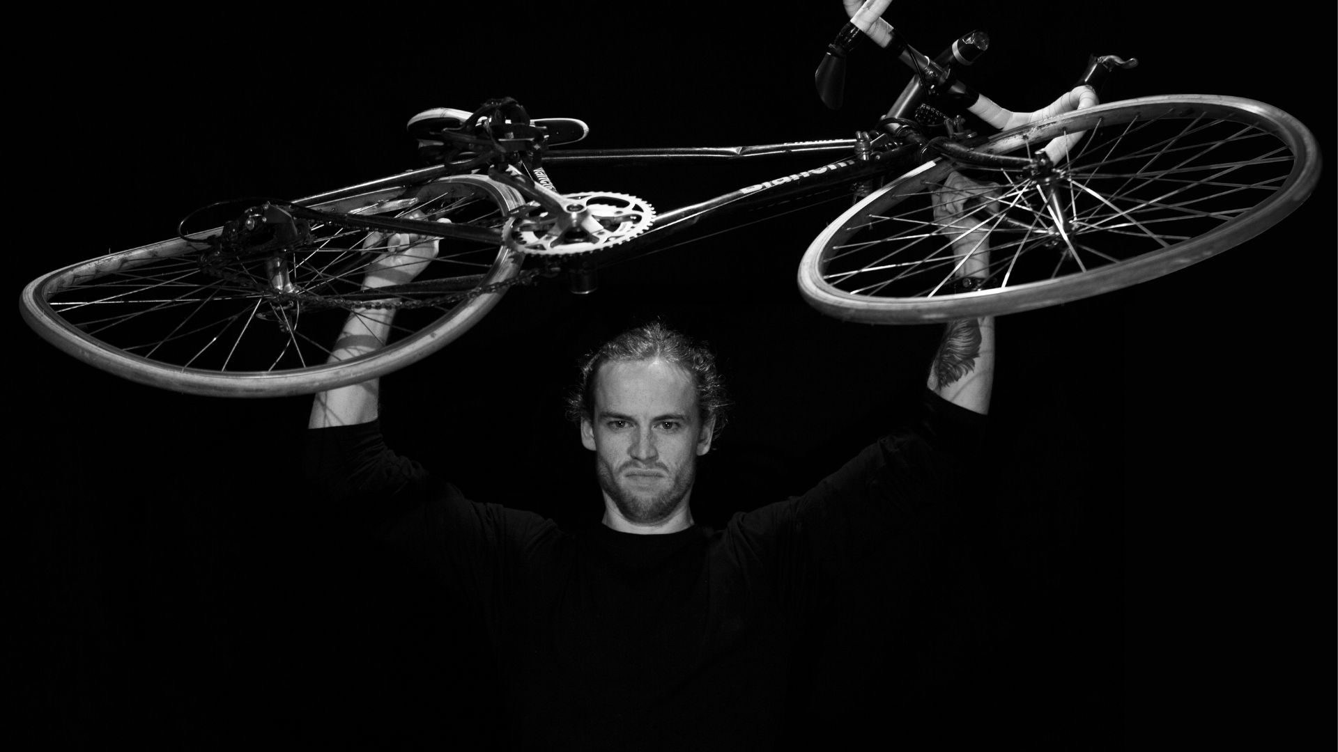 David Francisco lifts his bicycle overhead, a powerful symbol of God