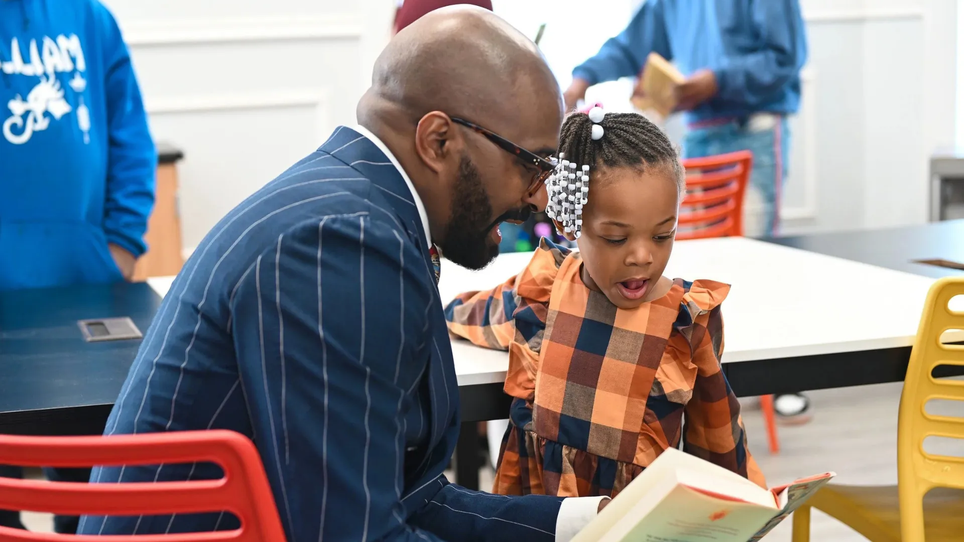 Pastor Chris Harris, Sr., reads to a young Chicagoan at a Bright Star event.