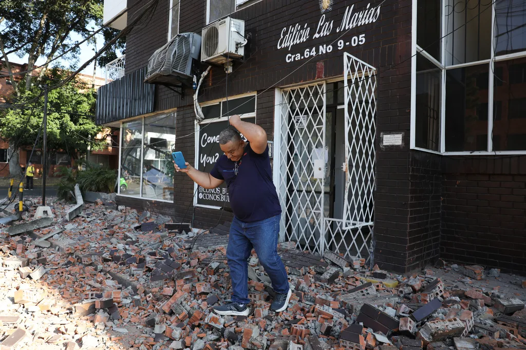 A man leaves an apartment building after an earthquake struck Cali, Colombia