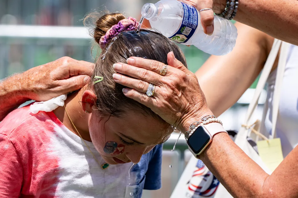 Ruth, 11, from Burke, Va., gets cold water poured on her head to cool off at the Great American State Fair on the National Mall