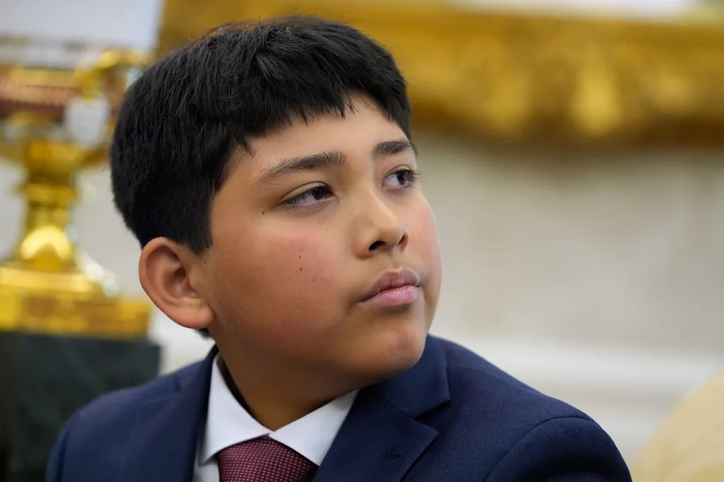 Nathaniel Rai listens as President Donald Trump meets with lifeguard Ryder Williams in the Oval Office