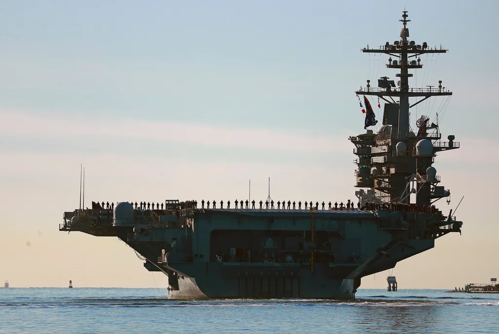Sailors and Marines line the deck of aircraft carrier USS Abraham Lincoln (CVN-72)