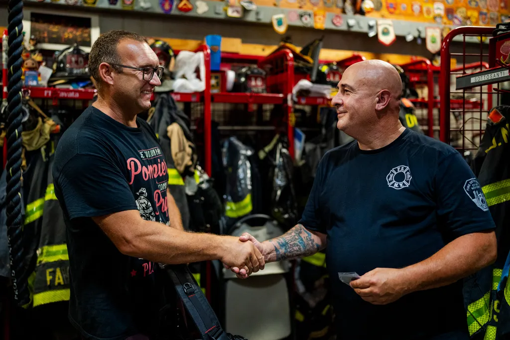 Firefighter Sal Argano, right, Ladder 10, greets Laurent Cosenefroy, a volunteer firefighter from France visiting New York and the FDNY "Ten House"