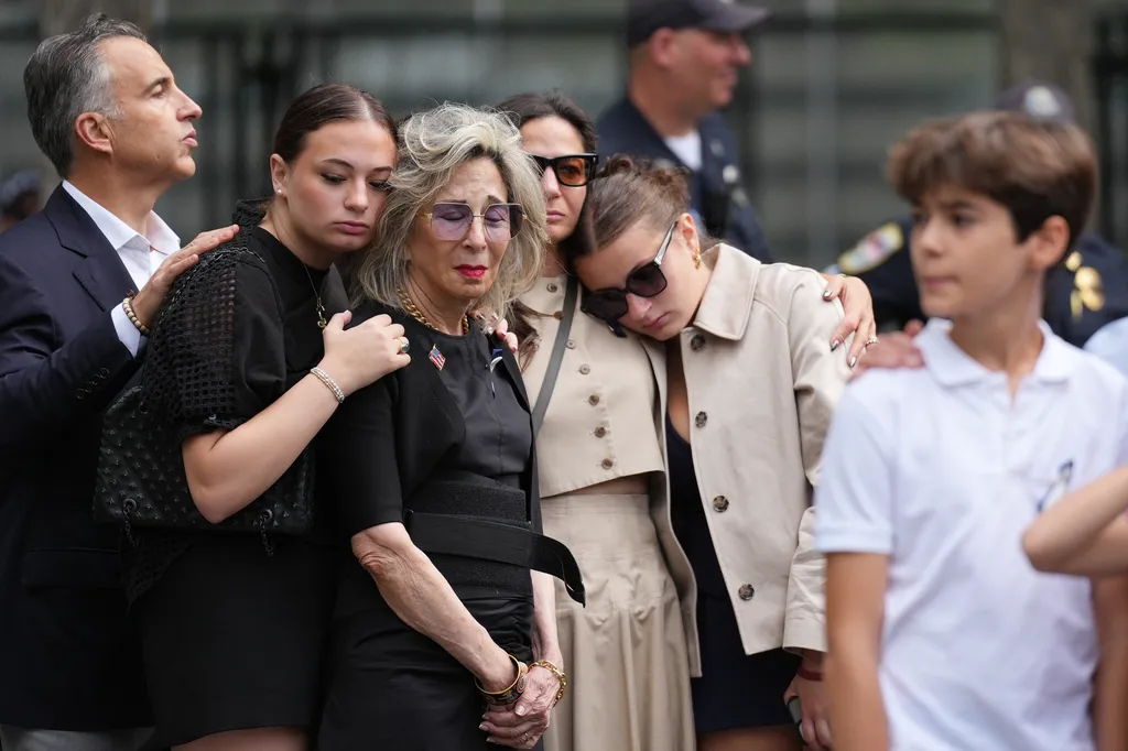 People listen to the U.S. national anthem at the memorial on the 25th anniversary of the September 11, 2001, terrorist attacks, Friday, Sept. 11, 2026, in New York.