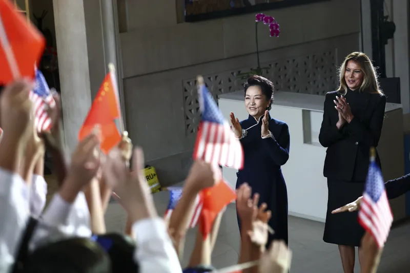 First lady of China Peng Liyuan, left, and first lady Melania Trump react as children perform during a visit to the Smithsonian
