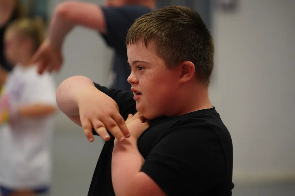 Tucker McGarrell, 13, who has Down syndrome, performs hand movements during a Dance Abilities class