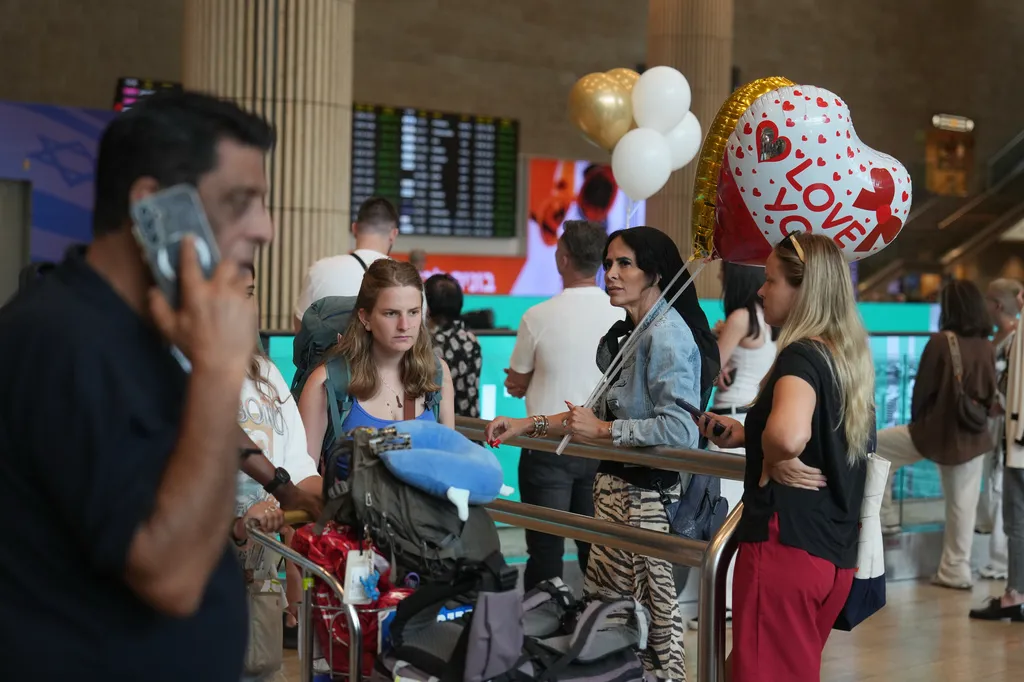 Holding balloons people wait for the arrival of passengers at Ben Gurion International Airport, near Tel Aviv