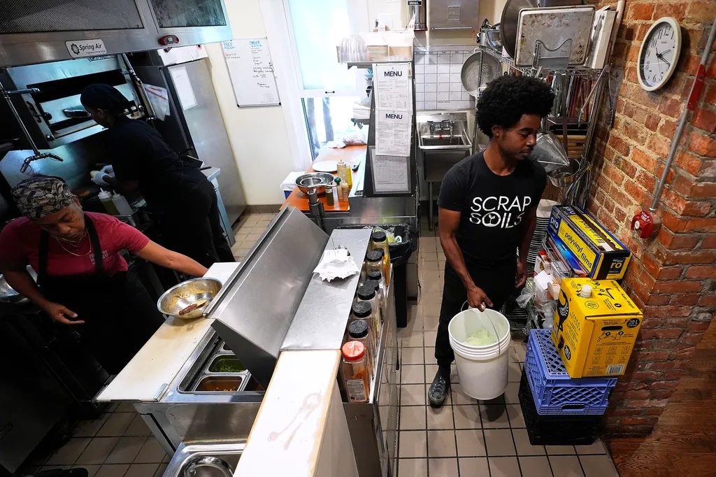 Ricky Blanding, founder of Scrap Soils, picks up compostable material from the BasBlue kitchen