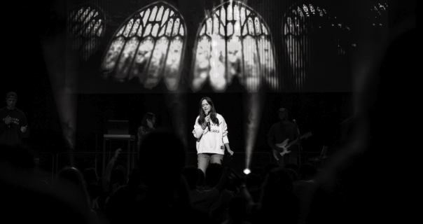 Woman speaking in front of stained glass