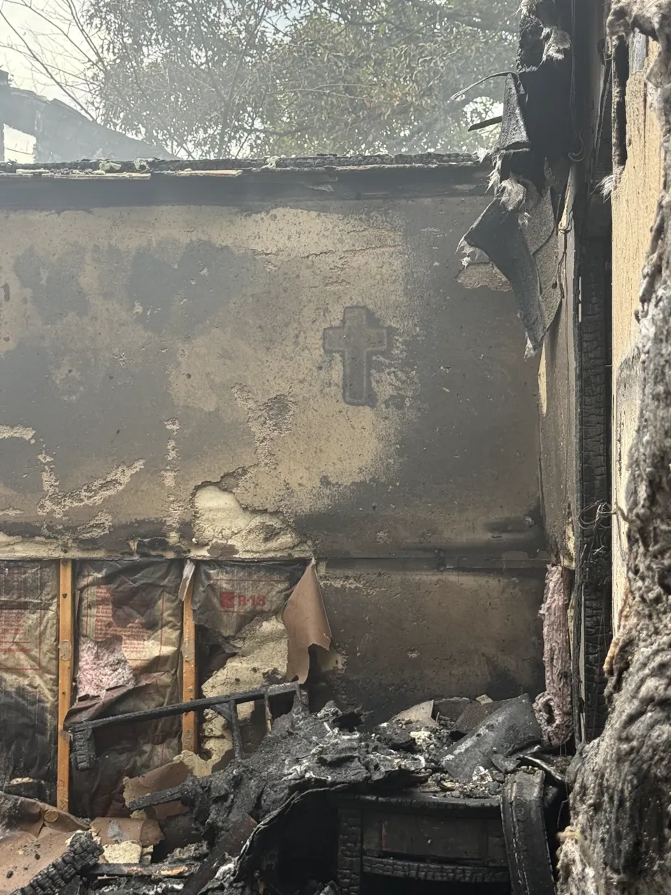 Cross still visible on charred wall