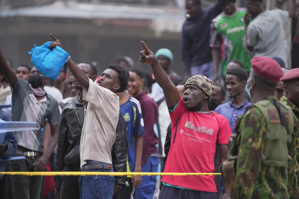People watch from behind a security cordon after a multi-story building collapsed 