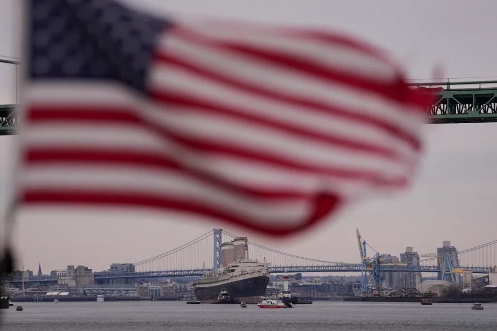 The SS United States is towed down the Delaware River between Pennsylvania and New Jersey, from Philadelphia