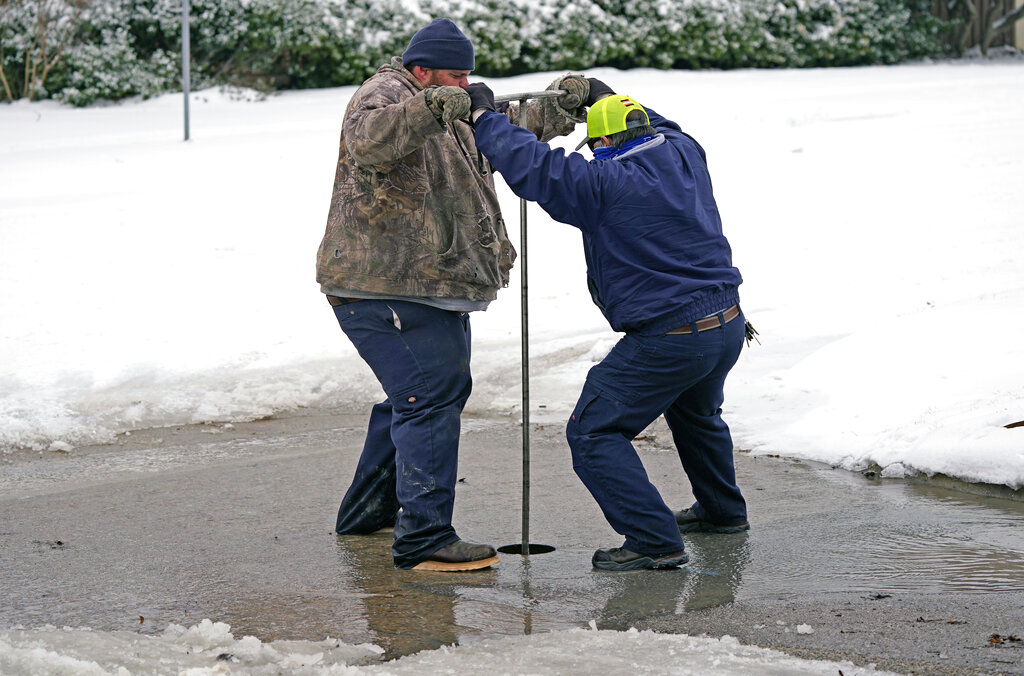 City of Richardson workers close a water main valve for a pipe that burst due to extreme cold