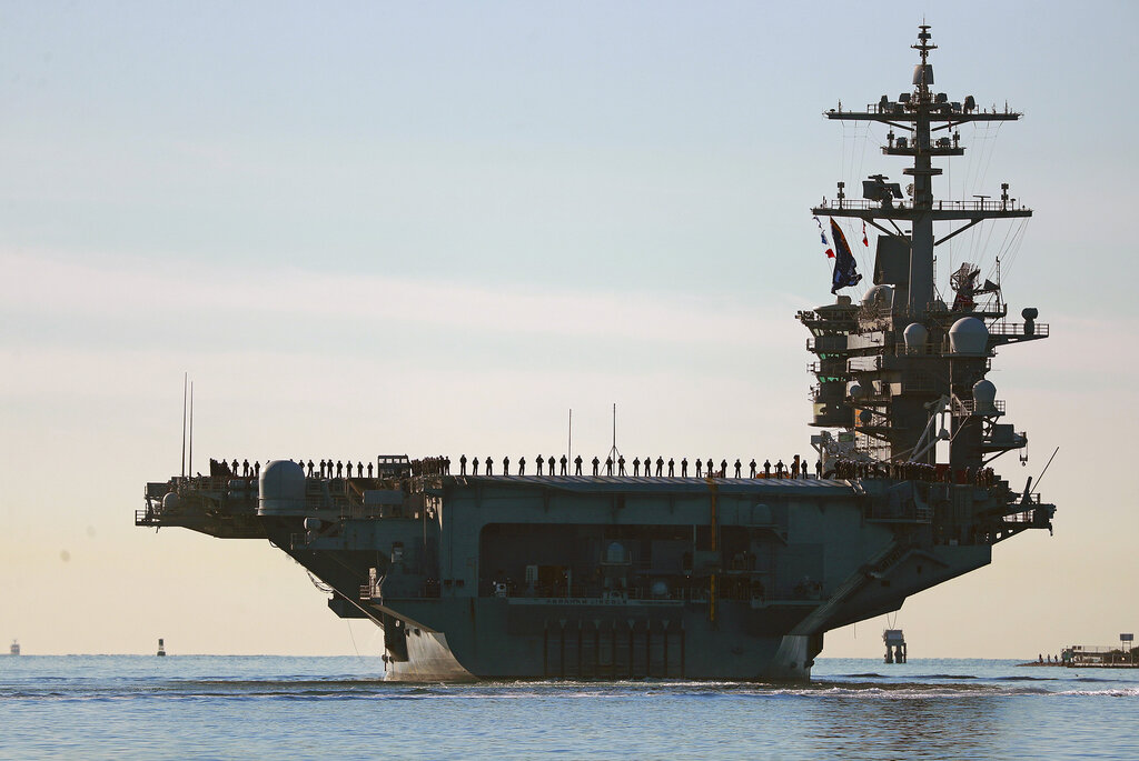 Sailors and marines line the deck of aircraft carrier USS Abraham Lincoln (CVN-72) as it deploys from San Diego on Monday, Jan. 3