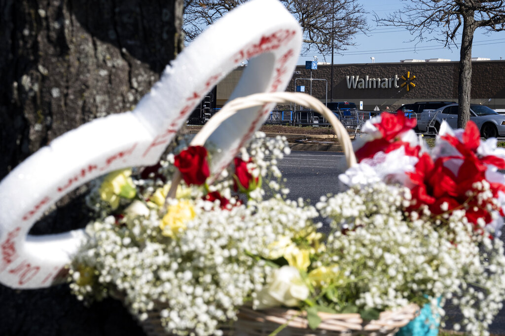 Flowers are placed by a tree outside a Chesapeake, Va. Walmart 