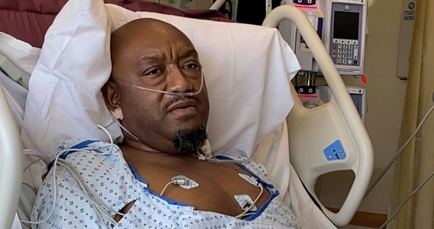 man lying in hospital bed with oxygen and monitors