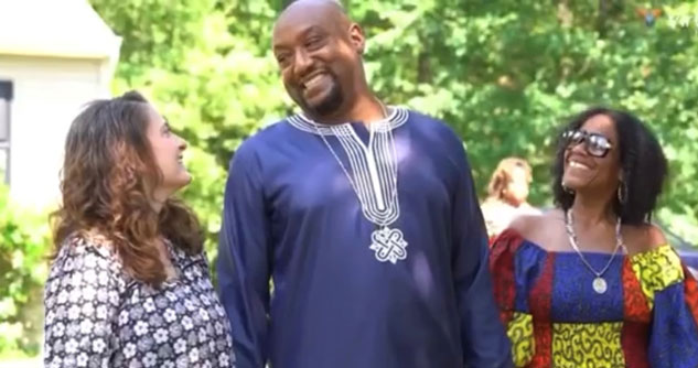 A woman next to a man and his wife, smiling