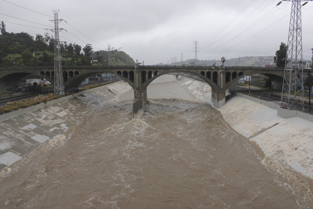 Rain-swollen Los Angeles River flows near downtown Los Angeles on Saturday