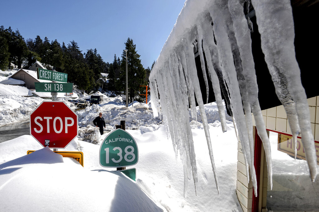 Snowfall surrounds businesses in Crestline, Calif.
