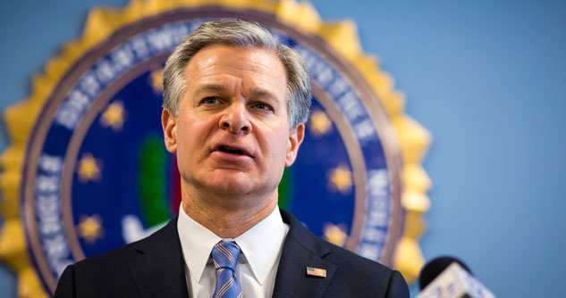 Man in suit and tie in front of the FBI seal