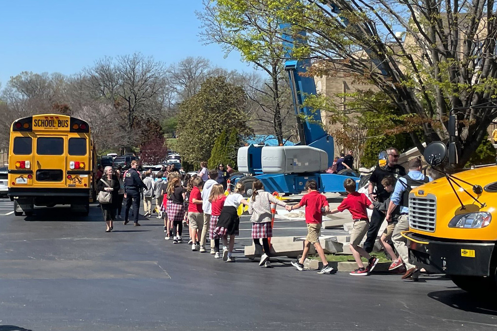 Children from The Covenant School, a private Christian school in Nashville, Tenn., hold hands as they are taken to a reunification site at the Woodmont Baptist Church after a shooting at their school, on Monday March, 27, 2023.