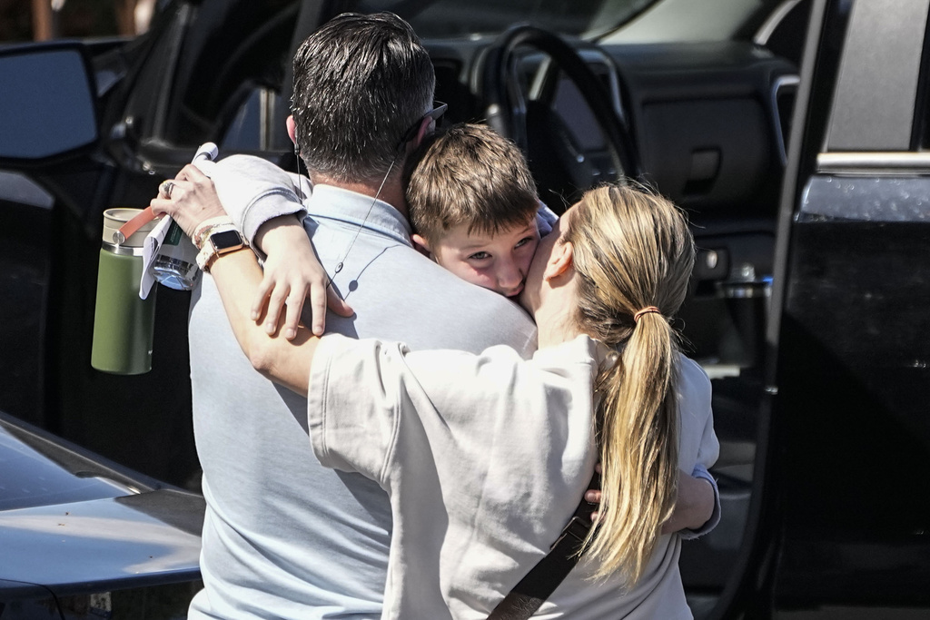 A woman kisses a child at the reunification center at the Woodmont Baptist church after a school shooting