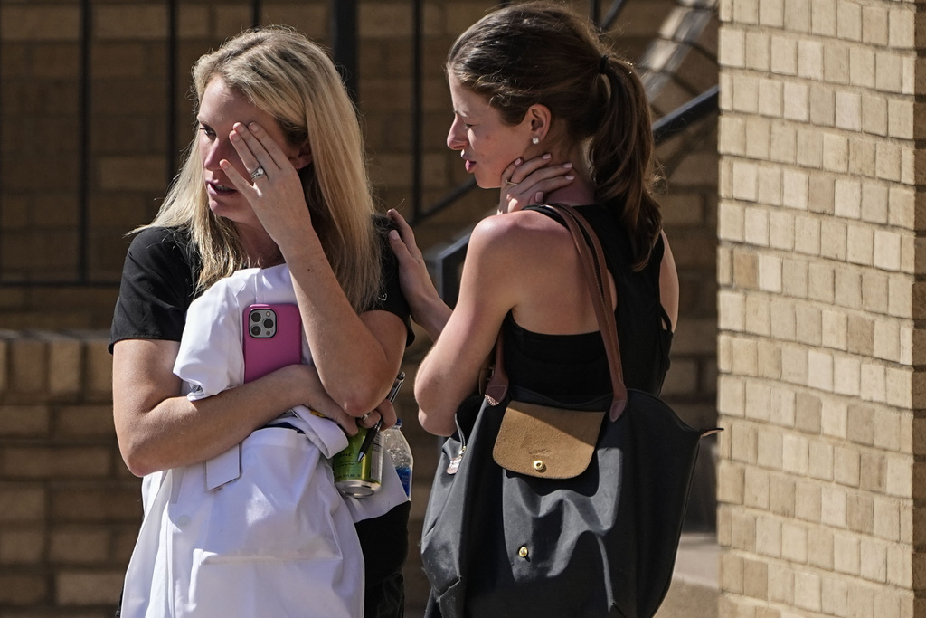 Women speak at the reunification center at the Woodmont Baptist church after school shooting