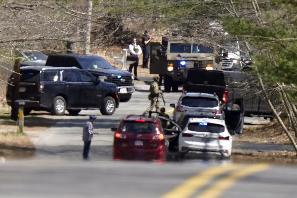 Members of law enforcement assemble on a road in Dighton, Mass., near where FBI agents converged on the home of a Massachusetts Air National Guard member
