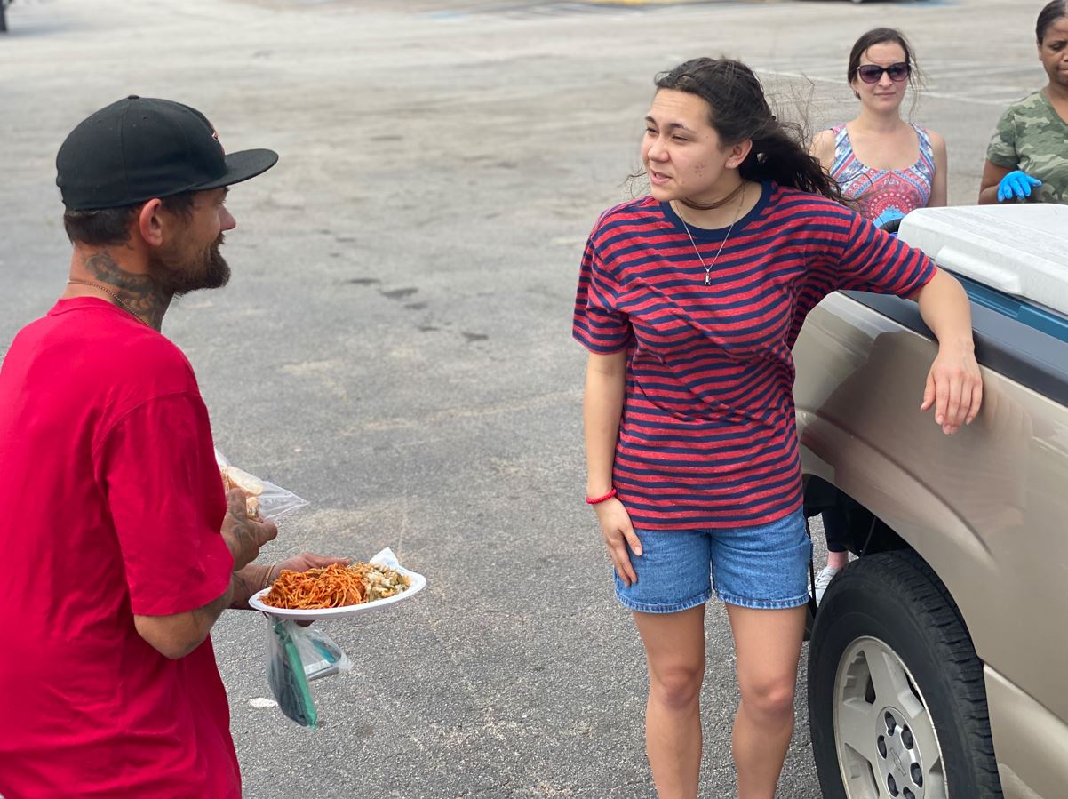 Hope Beyond Bridges volunteer feeding man experiencing homelessness