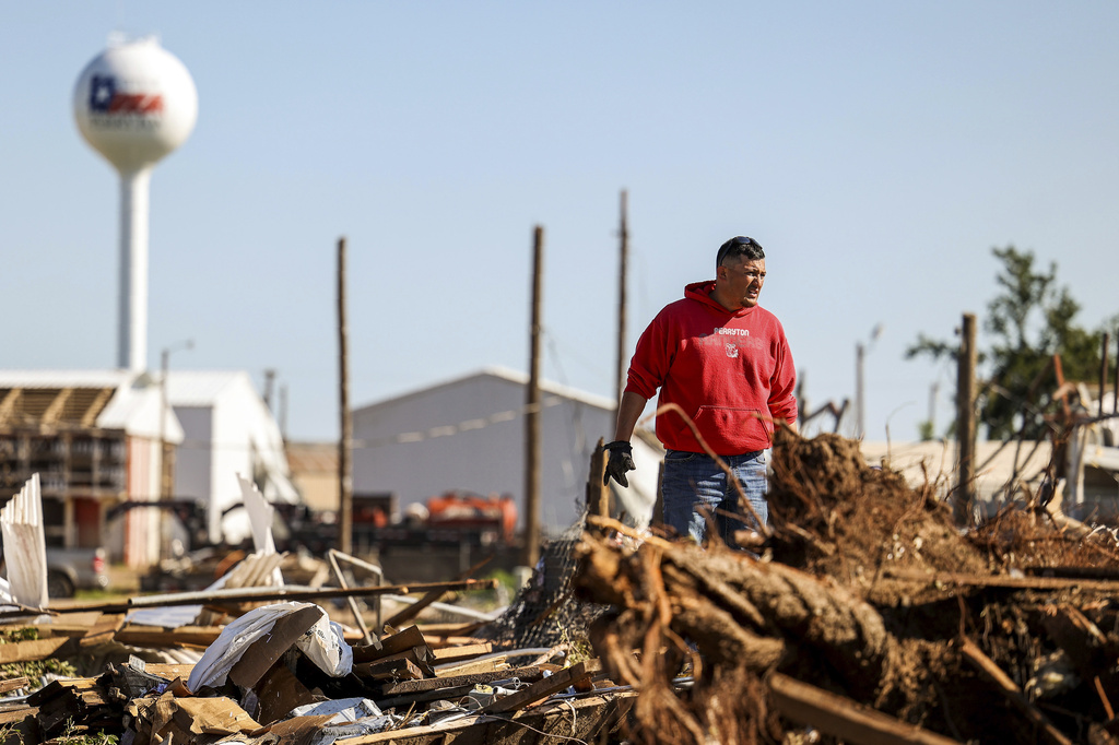 Adrian Herrera stands in debris of storage units that were damaged by Thursday