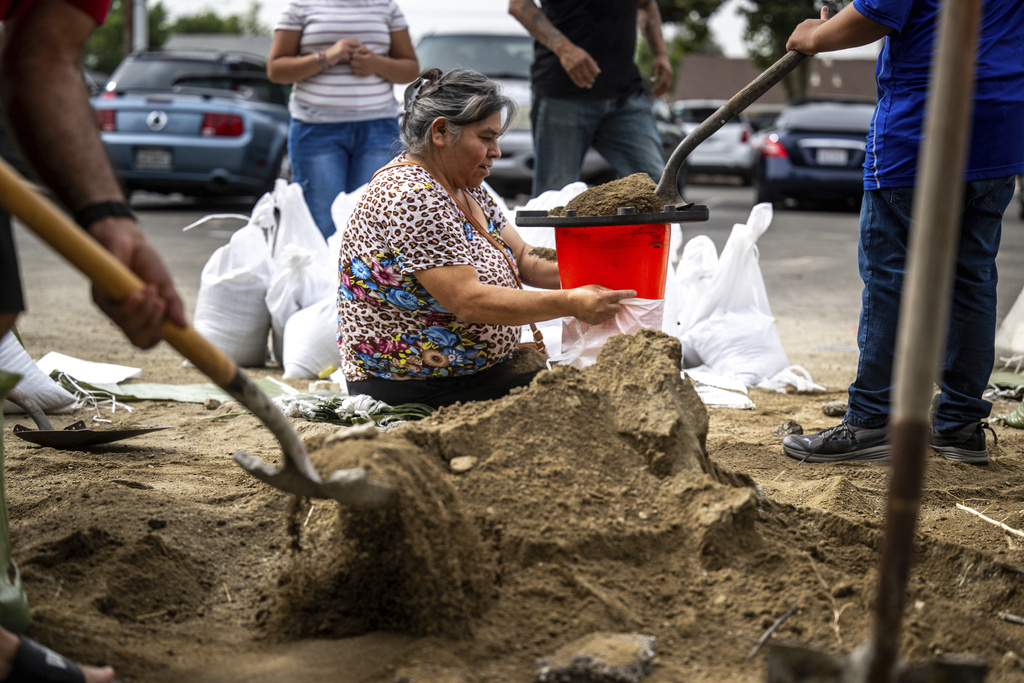 Norma Panilla attentively fills sandbags at Wildwood Park in San Bernardino, Cal., as she readies her home for potential floodwaters 