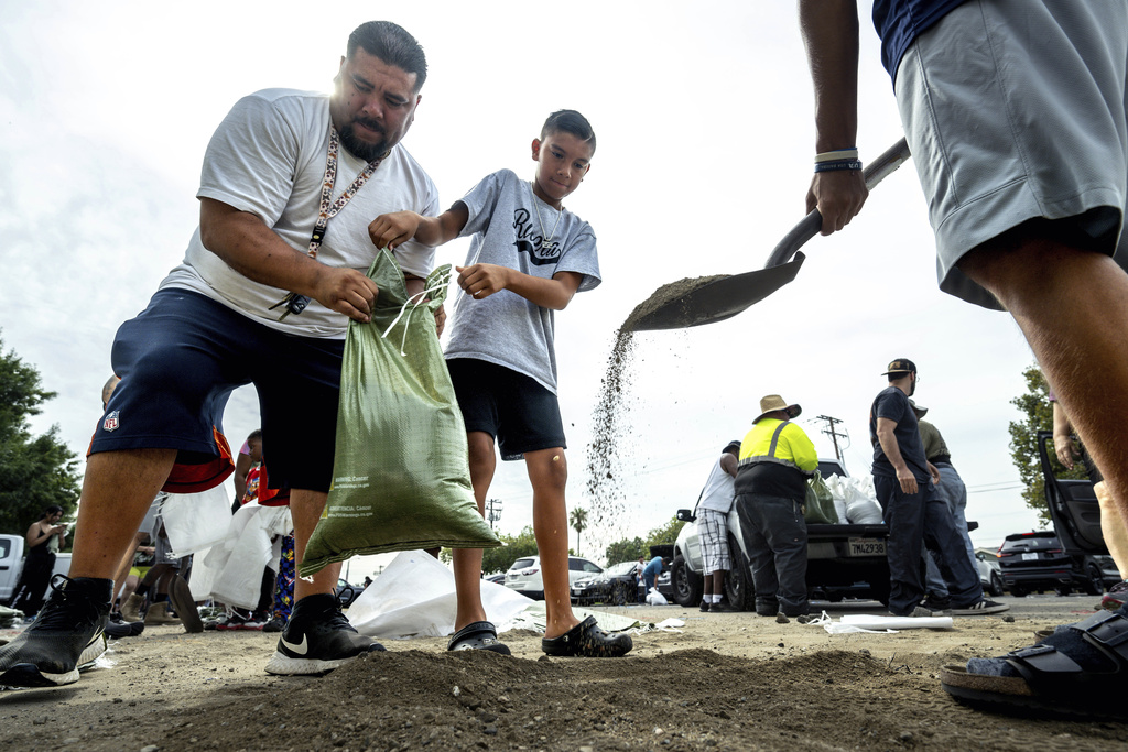 David Rivera makes sandbags with his sons, Zack, 10, center, and Vincent, 18, at Wildwood Park in San Bernardino, Ca.