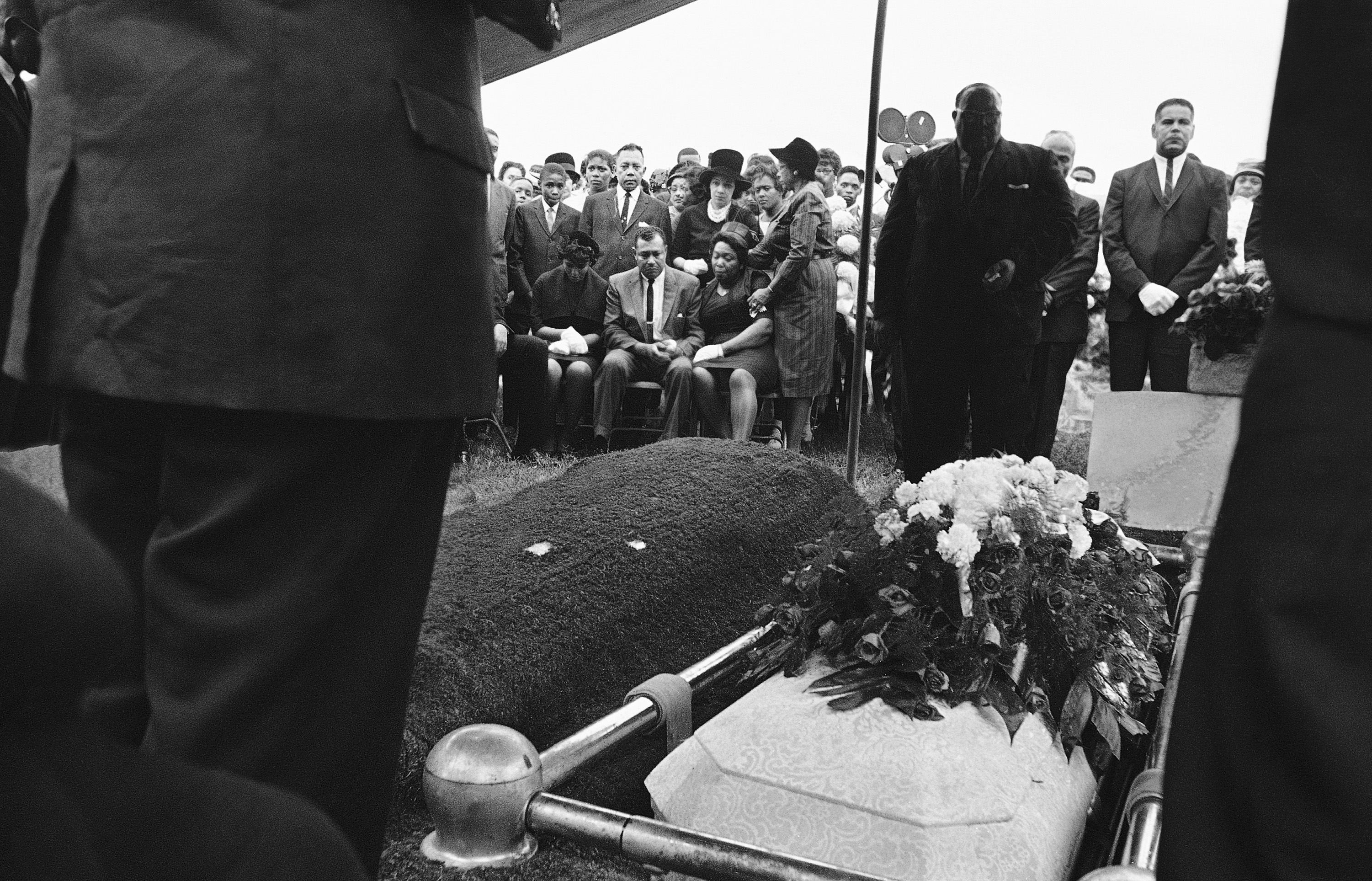 Graveside services with two caskets in the foreground.
