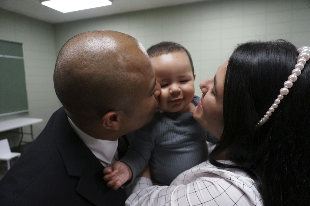 Rev. Gustavo Castillo, left, and his wife, Yarleny, play with their 7-month-old son, Gustavo Jr., after a worship service