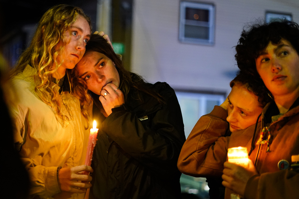People linger after a vigil for the victims of Wednesday