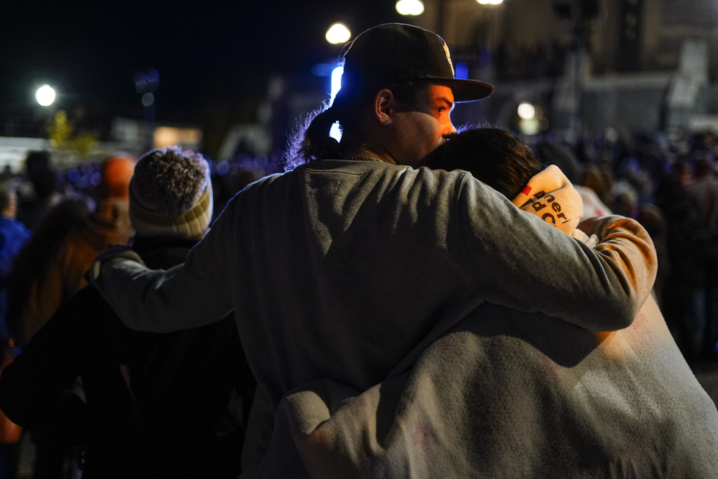 People linger after a vigil for the victims of Wednesday