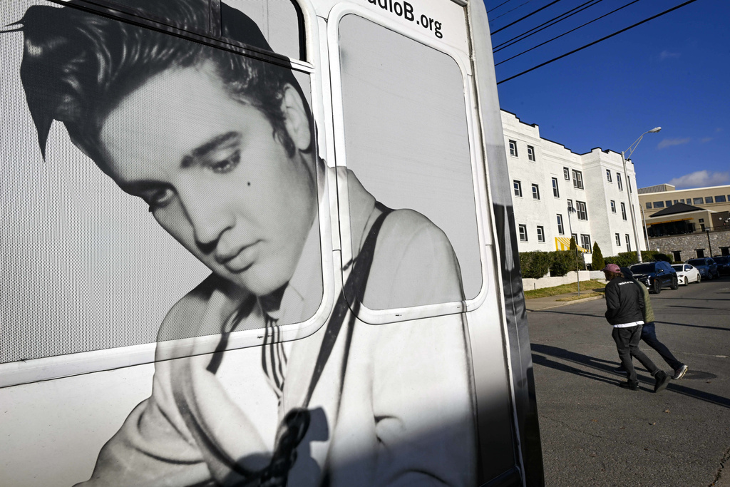 Pedestrians pass a tour bus with an image of Elvis shortly after Tennessee Gov. Bill Lee unveiled new legislation 