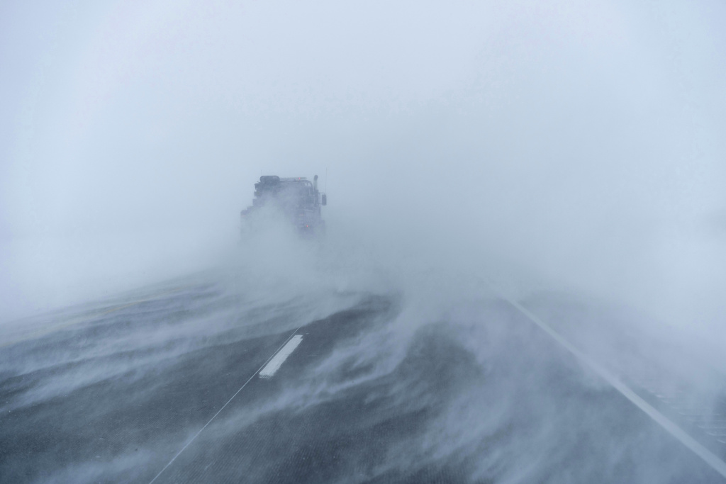 A truck moves along the snow-blown eastbound lane of US Highway 20 during a blizzard near Sac City, Iowa