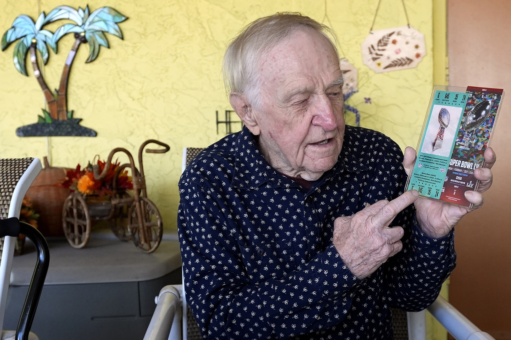 Tom Henschel holds up tickets to quarterback Tom Brady