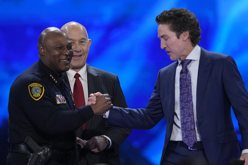 Pastor Joel Osteen, right, shakes hands with Houston Police Chief Troy Finner during a service at Lakewood Church