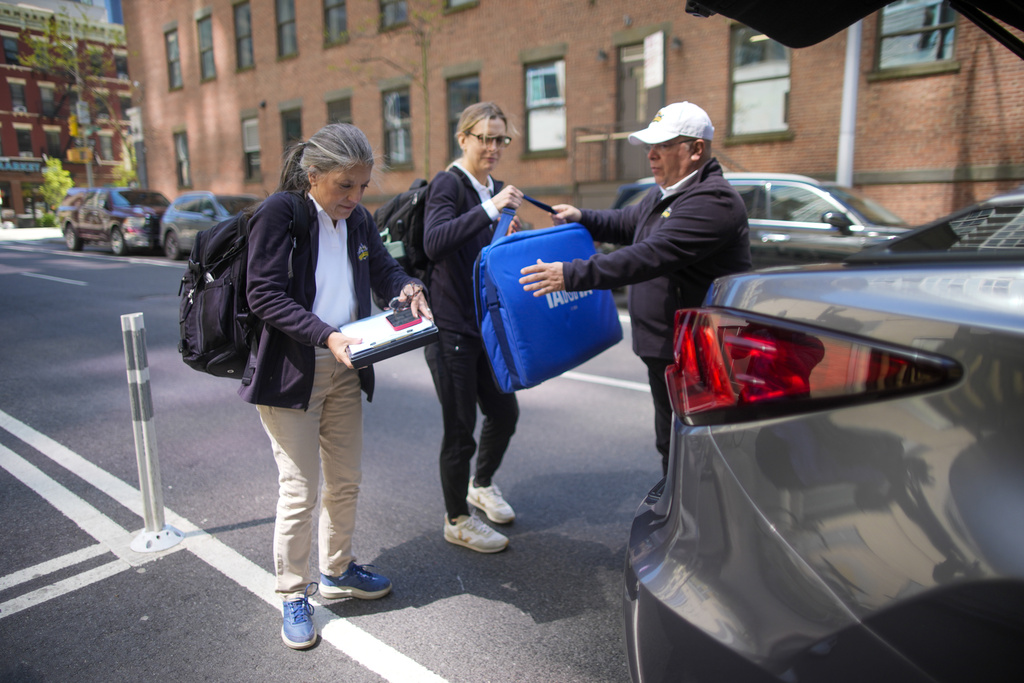 Dr. Amy Attas, left, and licensed veterinary technician Jeanine Lunz, center arrive at a clients apartment building
